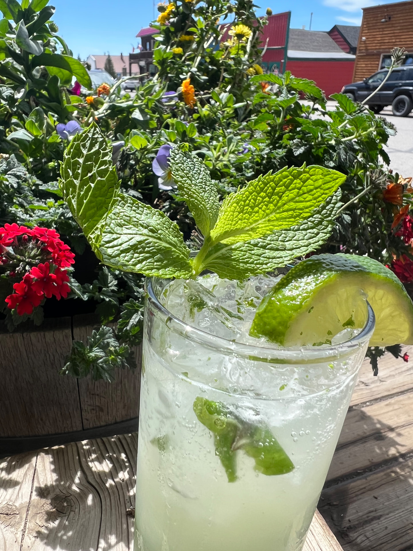 A tall mint mojito with lime and crushed ice on the patio