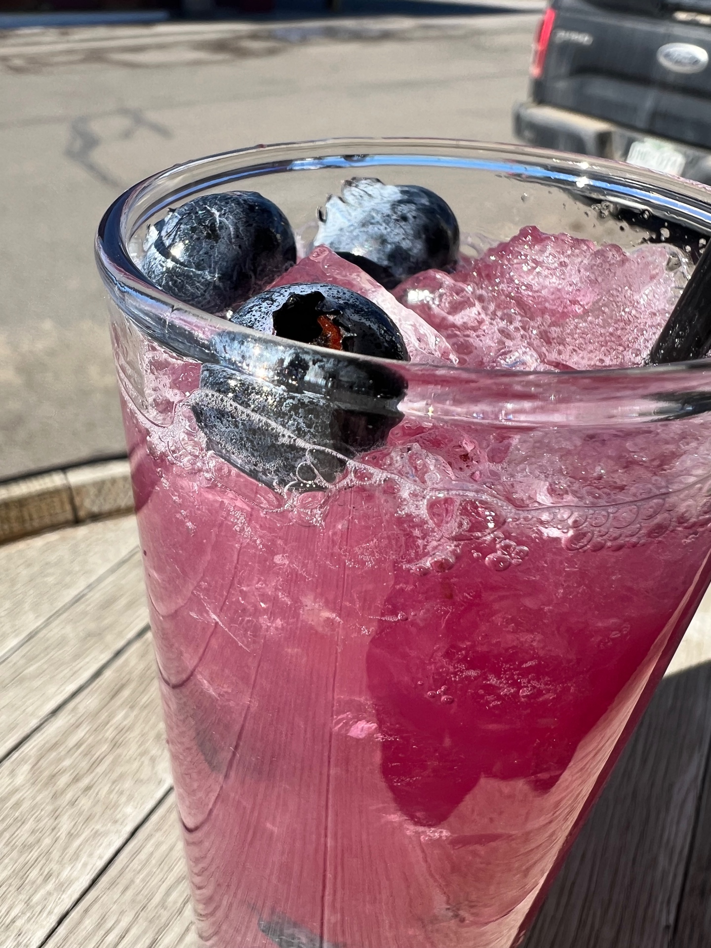 A bright pink blueberry fizz over crushed ice on the sunny front patio