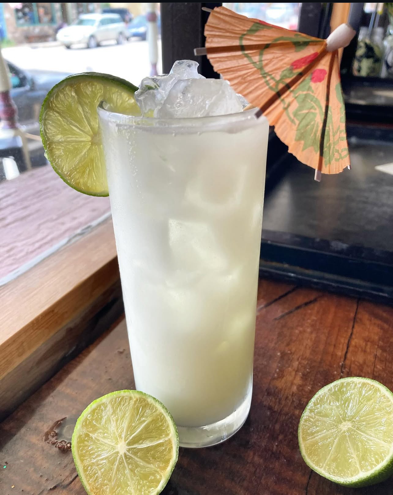 A frosty coconut-lime cooler with a lime wheel and paper umbrella