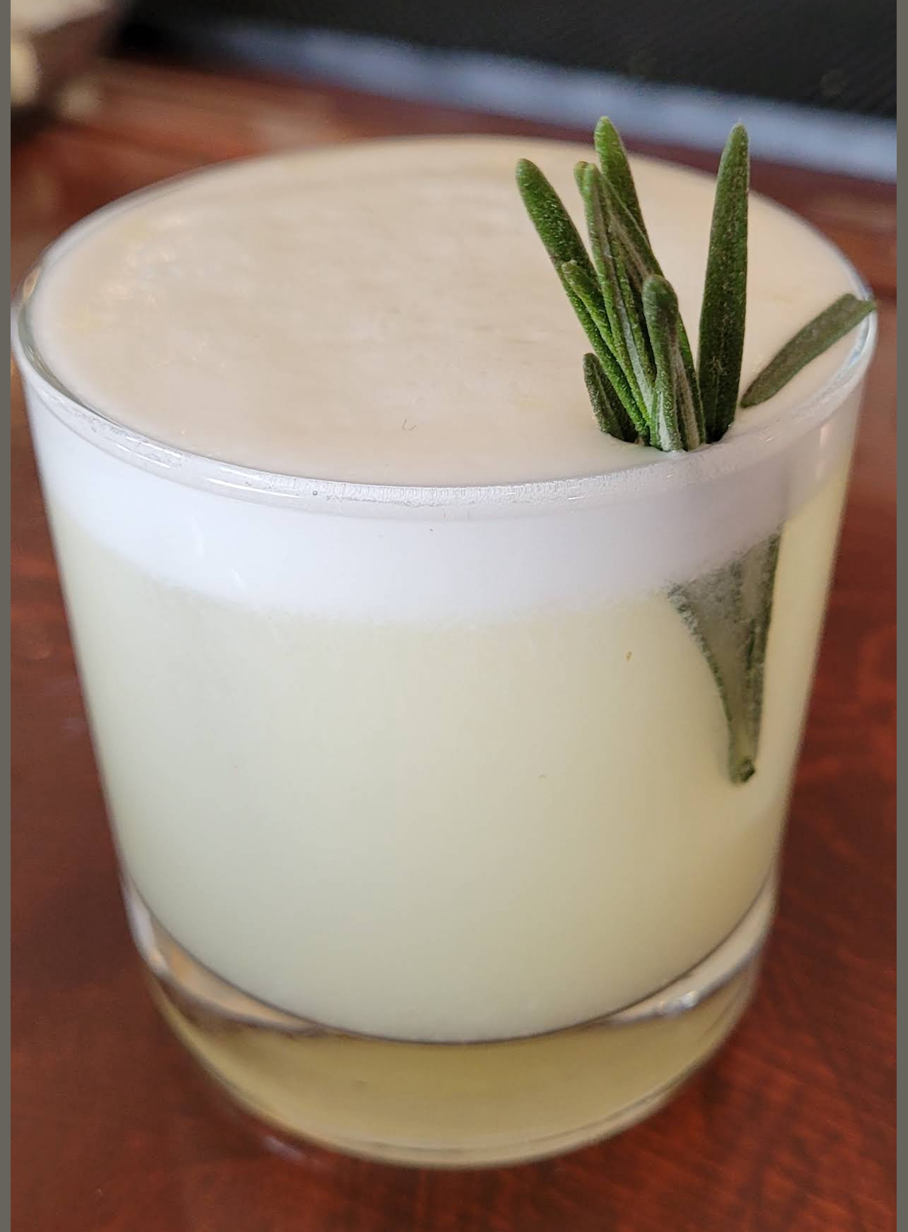 A creamy egg-white sour with a fresh rosemary sprig