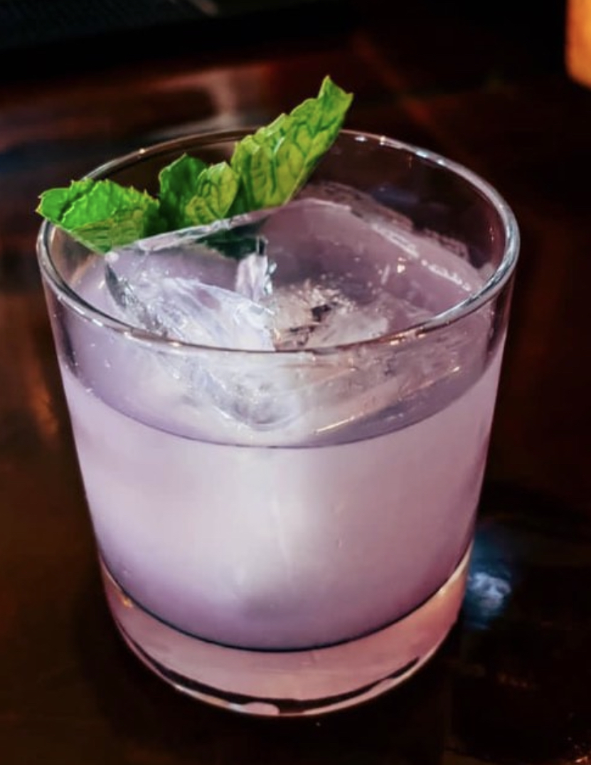 A lavender cocktail over ice with fresh mint in the tasting room