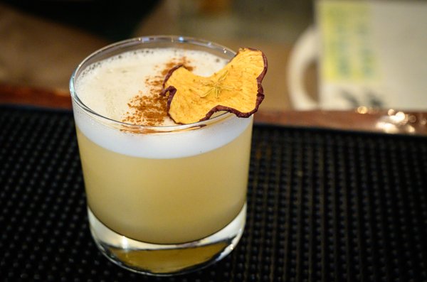 A cinnamon-dusted apple sour topped with a dried apple chip