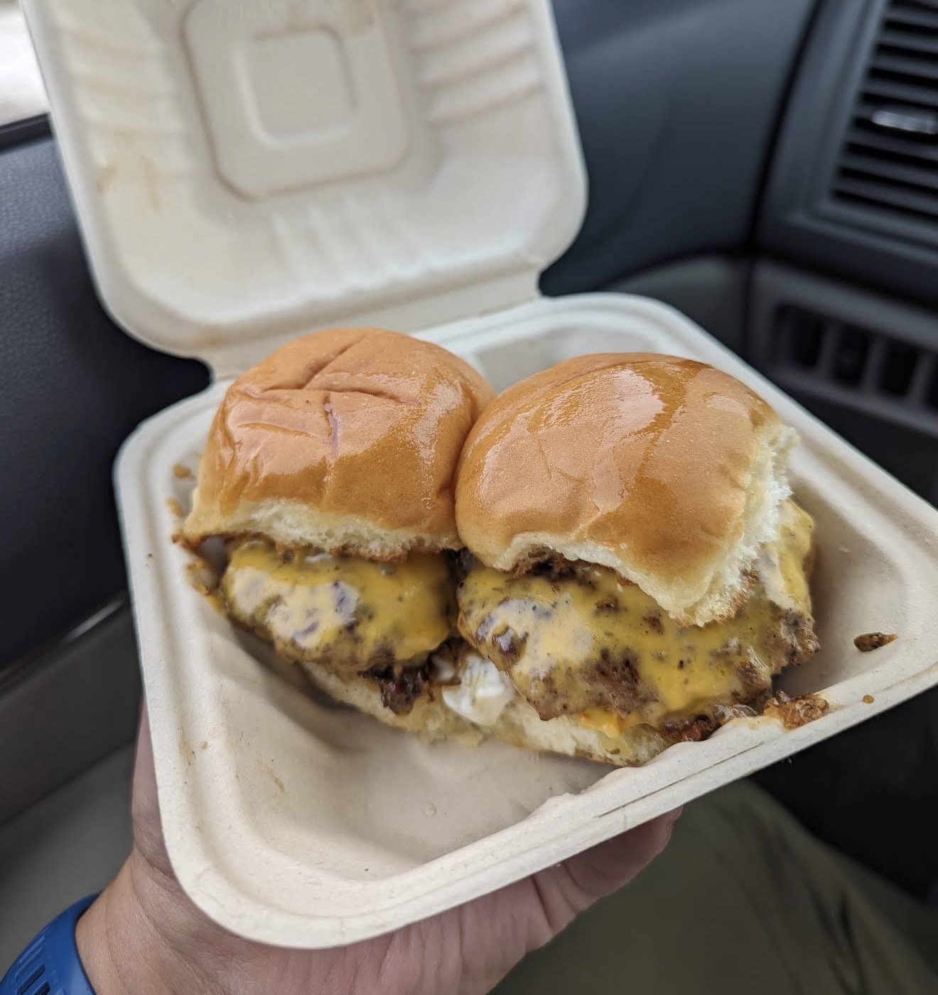 Two griddled smash-style cheeseburger sliders on toasted brioche buns