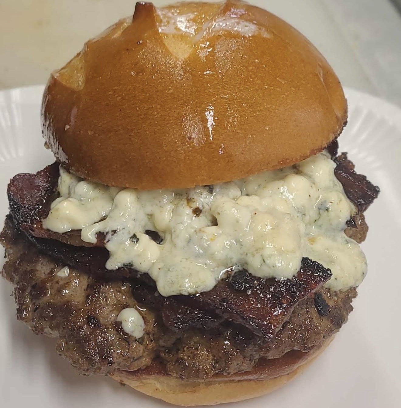A juicy pretzel-bun burger piled with bacon and melted blue cheese