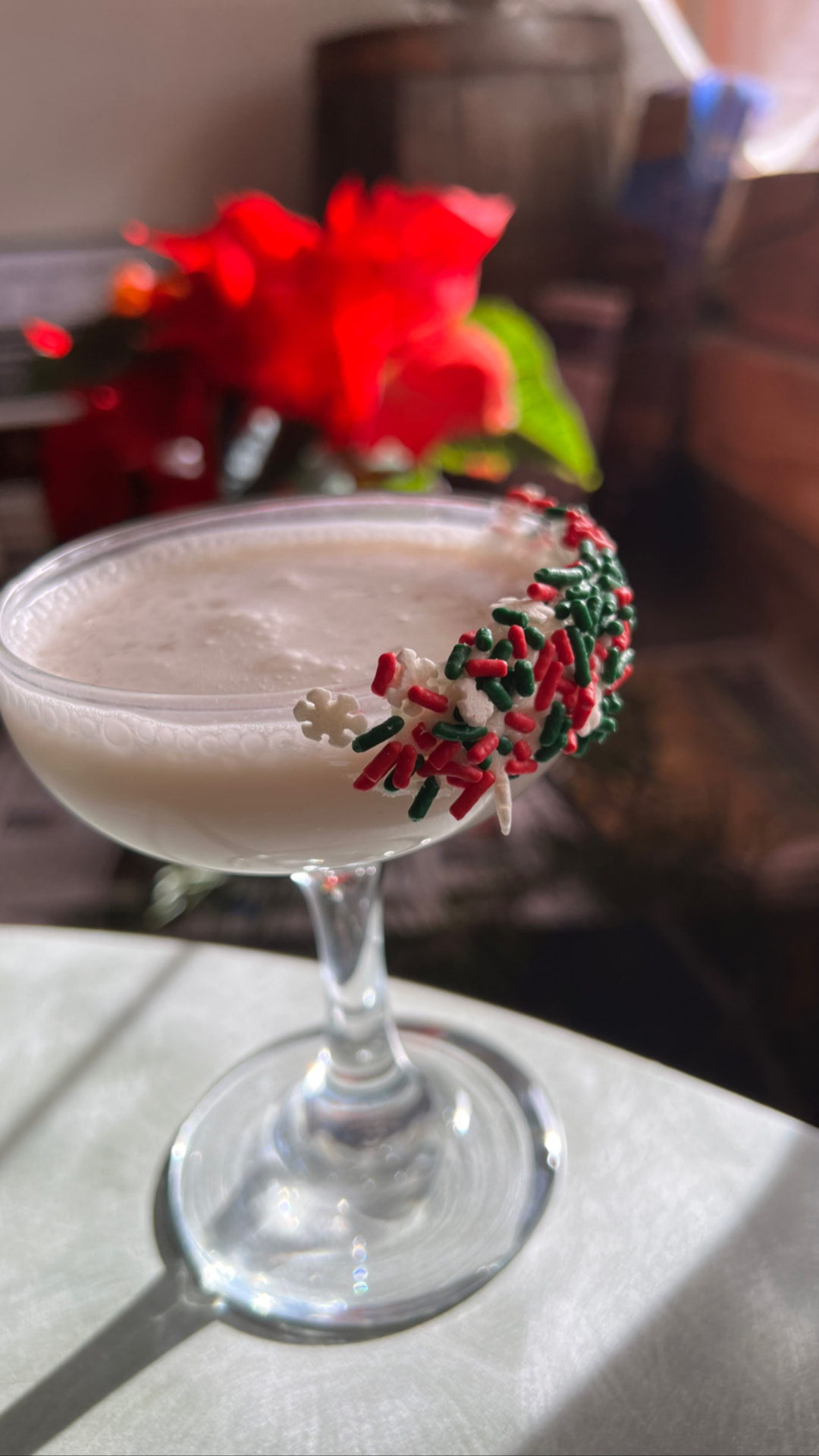 A creamy holiday coupe rimmed with red and green sprinkles