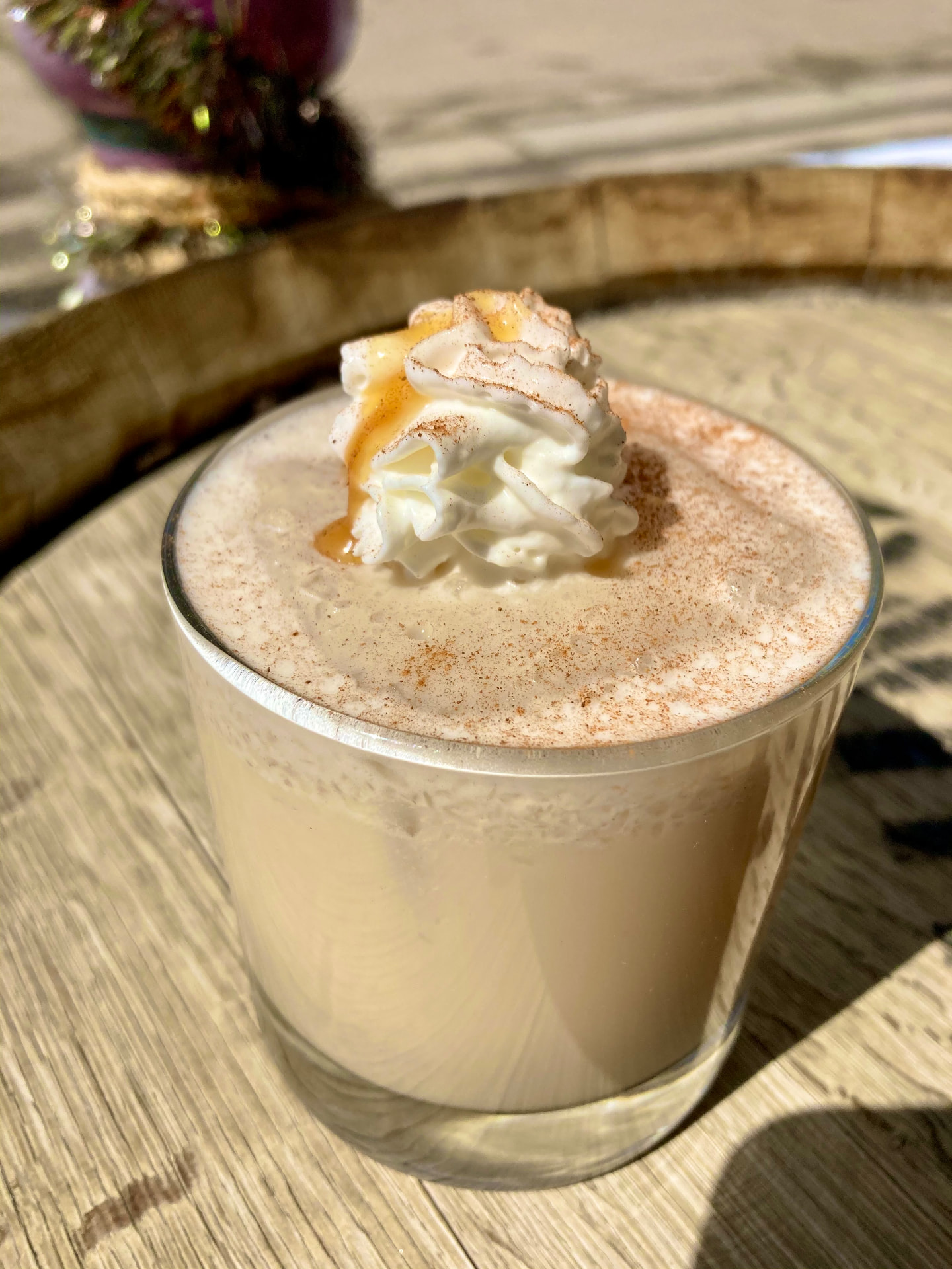 A creamy caramel cocktail dusted with cinnamon and topped with whipped cream