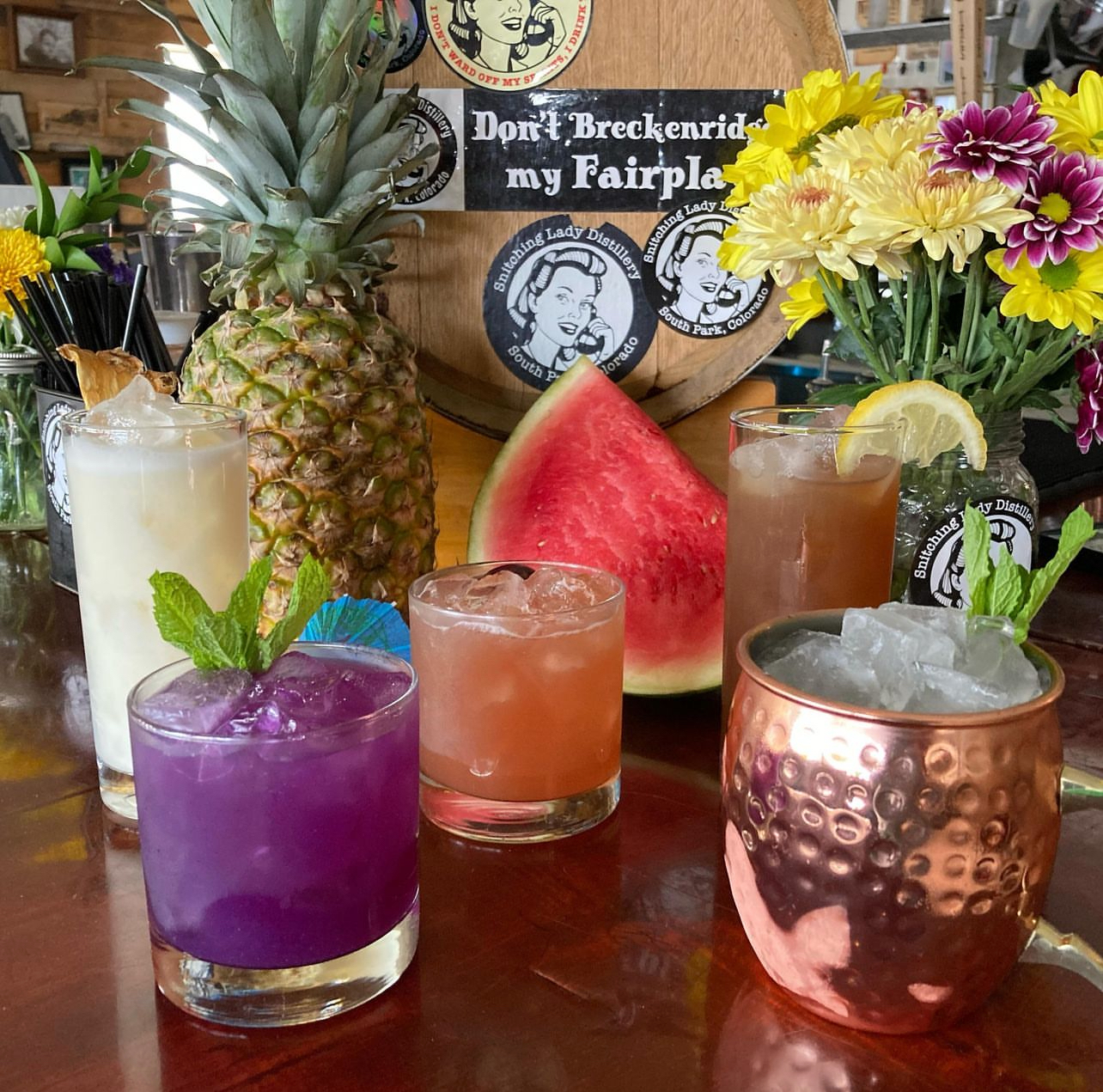 A colorful spread of five cocktails with pineapple and watermelon in the tasting room