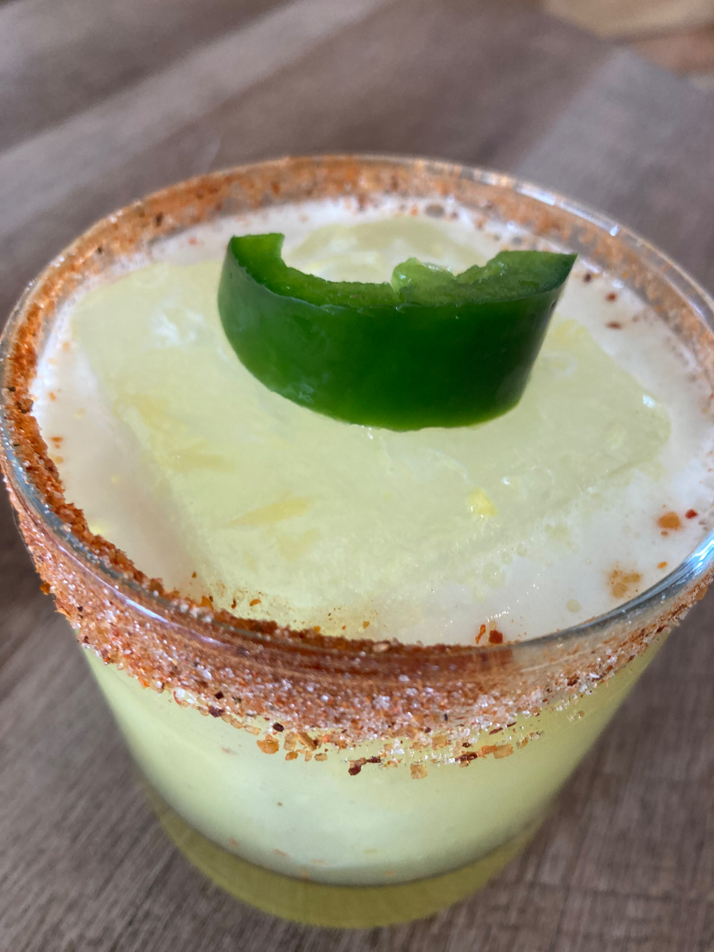 A chili-salt rimmed jalapeño margarita with a fresh pepper slice