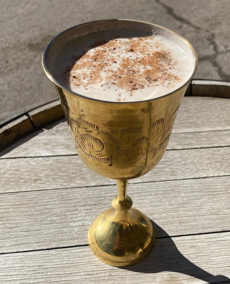 A creamy nutmeg-dusted cocktail in an etched brass goblet