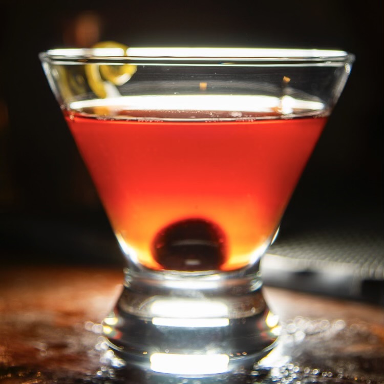 A ruby-red Manhattan with a brandied cherry and lemon twist