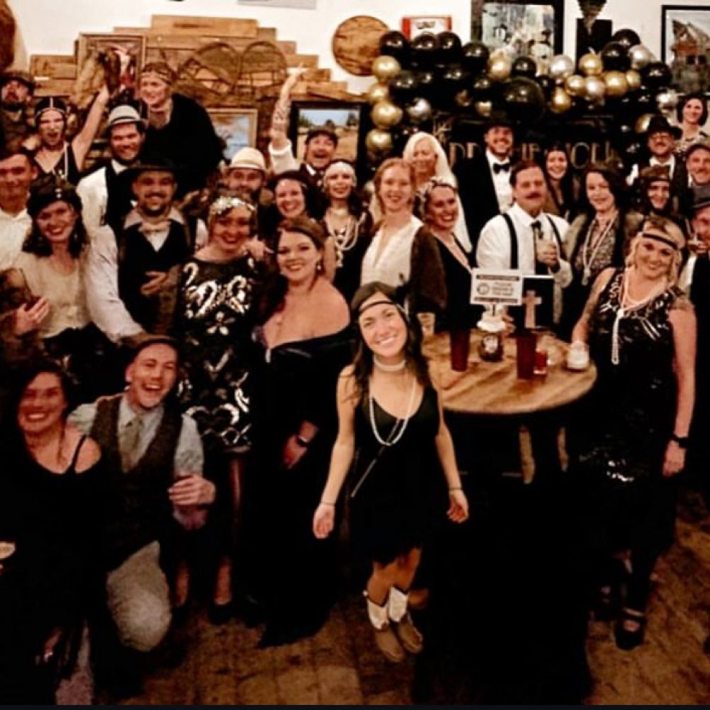 New Year's Eve revelers in 1920s attire raising a toast